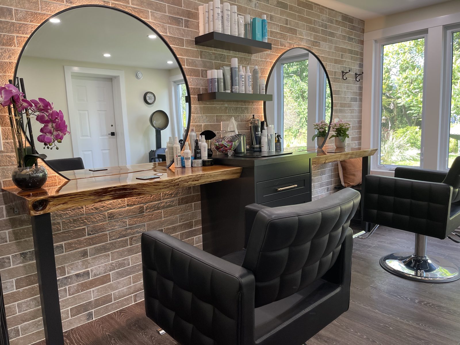 Interior of Scissor Shack Studio with styling chairs, round mirrors and a garden view